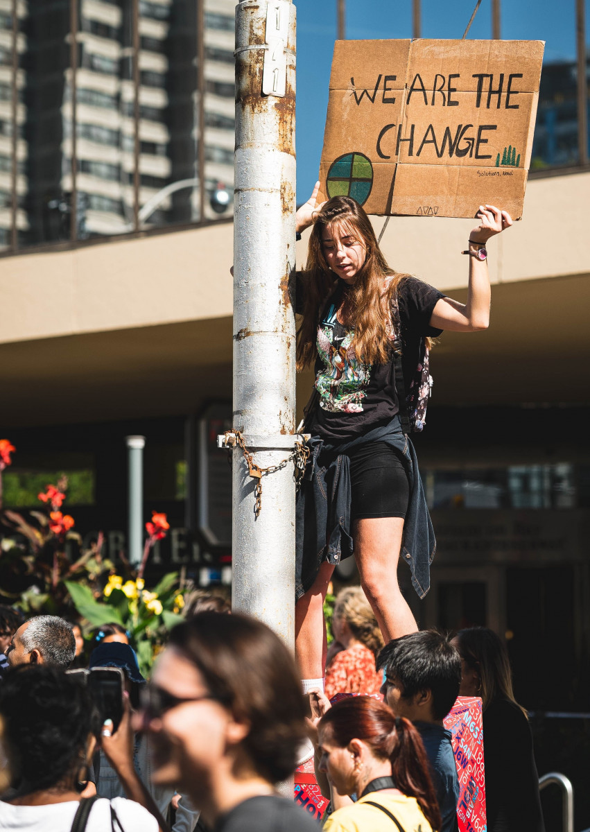 Young climate change protestor with a banner saying '